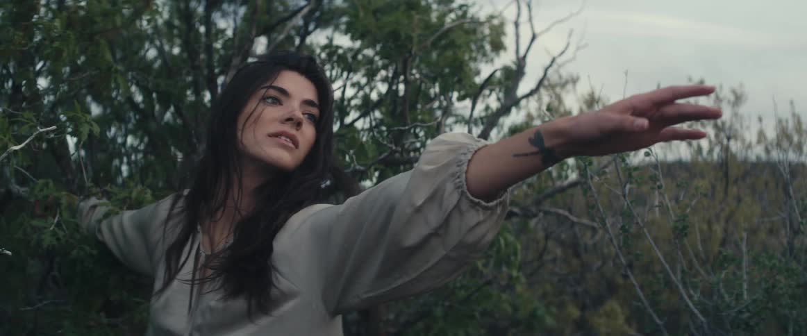 A woman is standing by some trees in spring