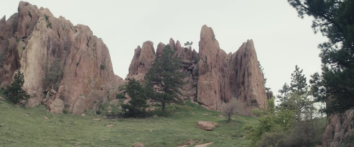 A large rock formation on a grassy hill