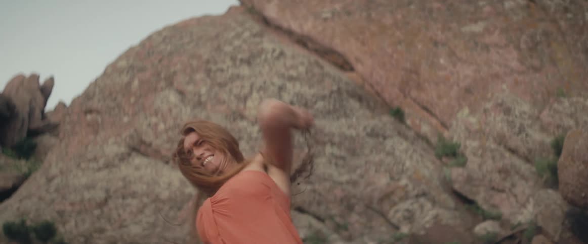 A woman lifts up a rock and throws it