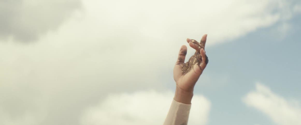 A woman raises her arms in the desert