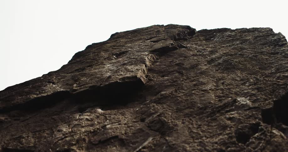 A tall rock cliff towers towards the sky