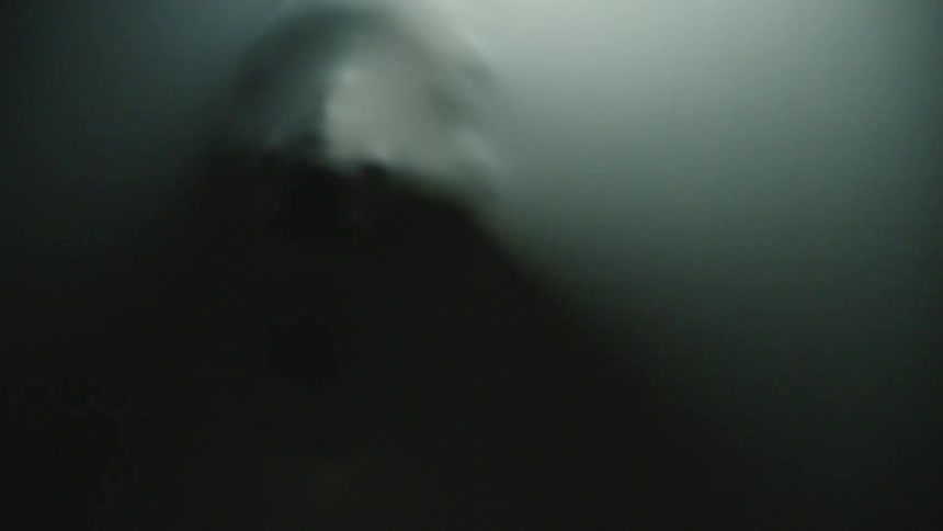 A mans face is stretching through the elastic wall