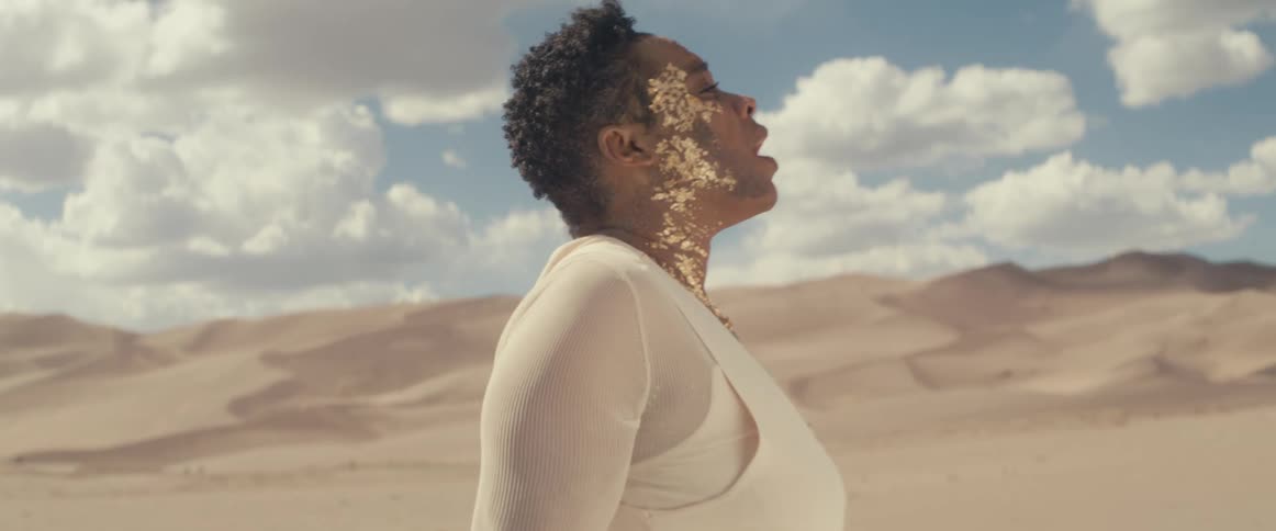 A person is laying in the sand in a desert