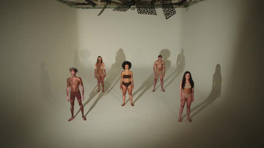 Models stand in a room with a flashing light