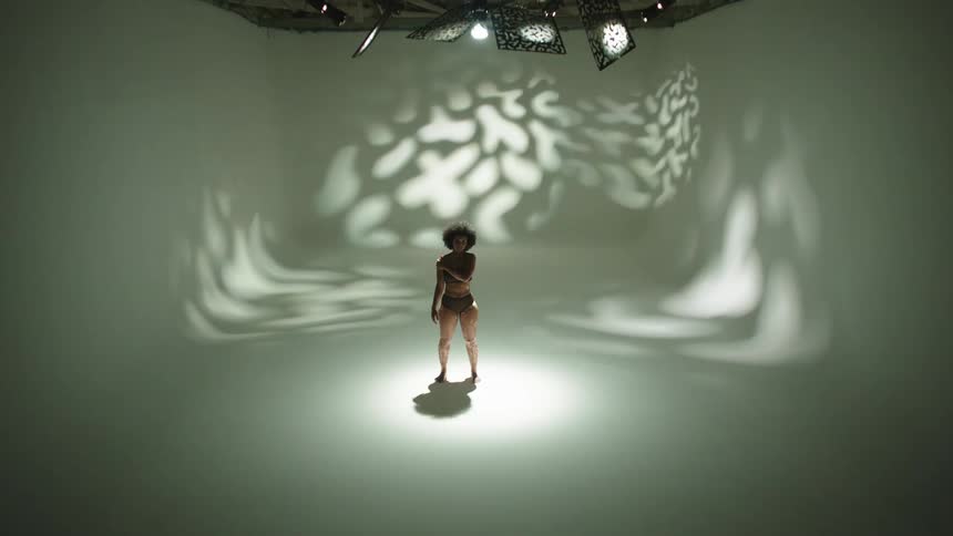 A portrait of a woman standing in a white studio