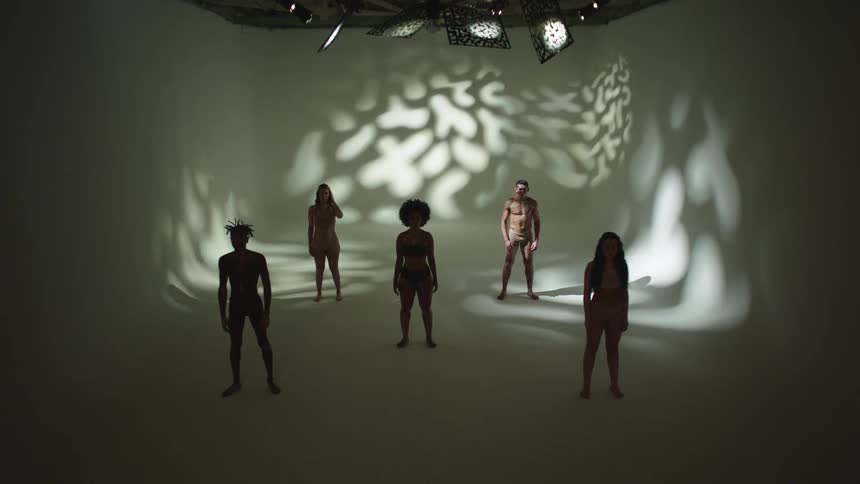 Models pose in their underwear under bright lights in a studio