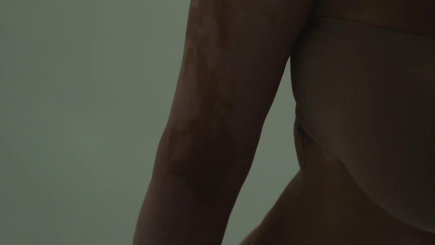 A woman stands in the room alone