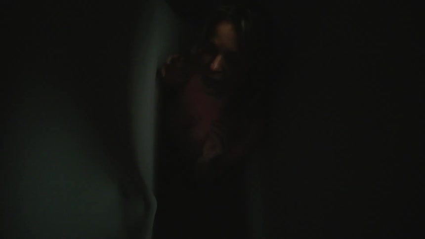 The walls in the narrow hall are moving around a trapped woman
