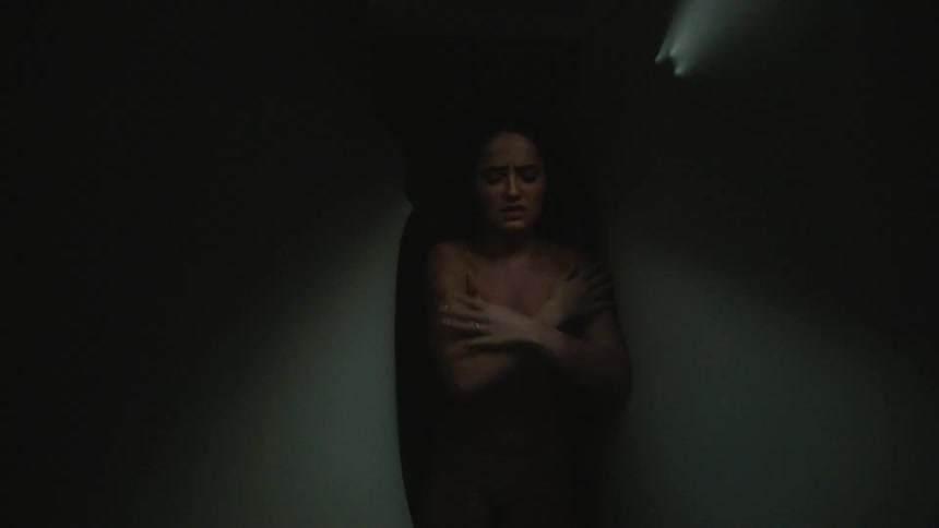 A woman walking through a hallway with moving walls