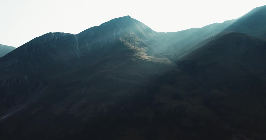 Sun shines rays through the fog in the saddle at top of mountain