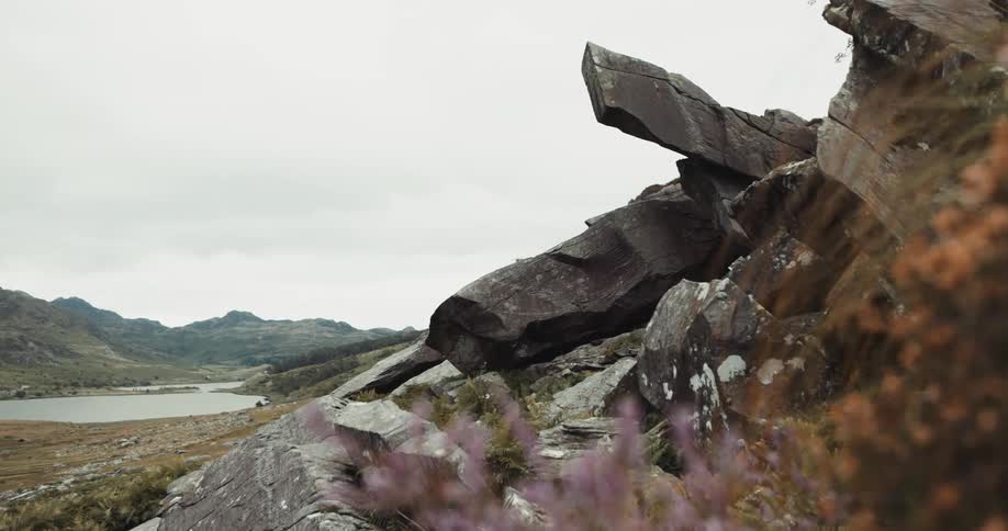 Rocky hill with distant lake on cloudy day