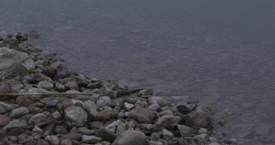 A rocky shoreline and clear, still water