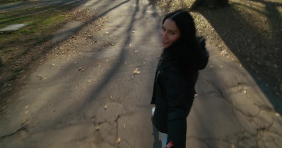 Young couple walking in a park holding hands in autumn at morning