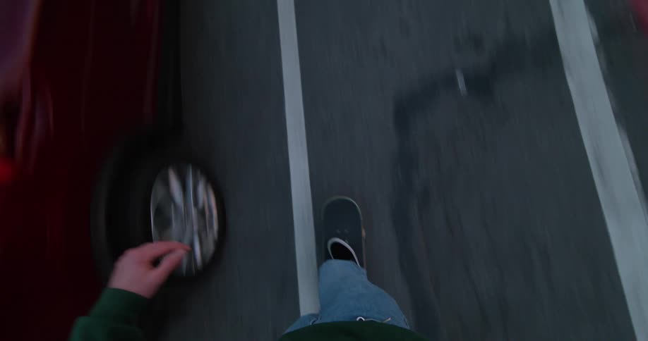 Point of view footage of a man riding a skateboard on a street