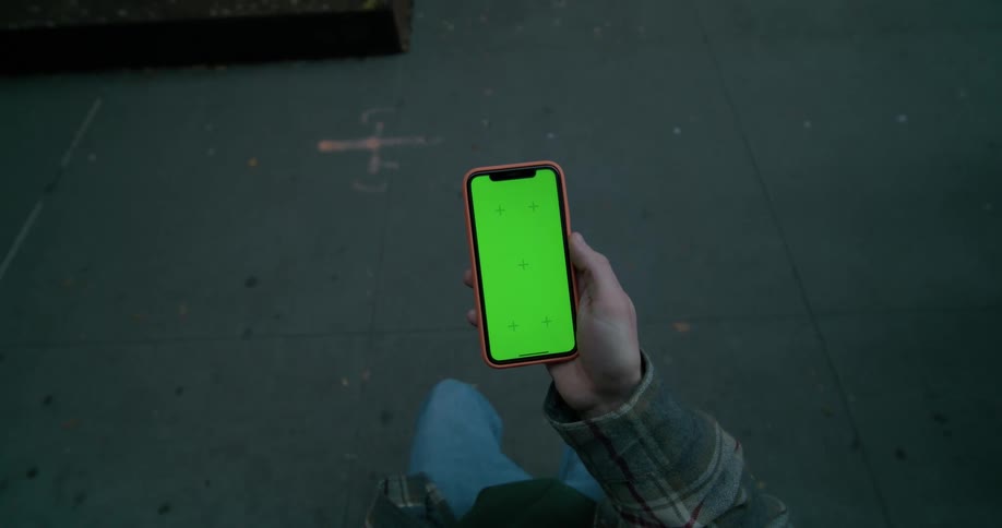 A mans hand holding a smartphone tapping the screen with his thumb
