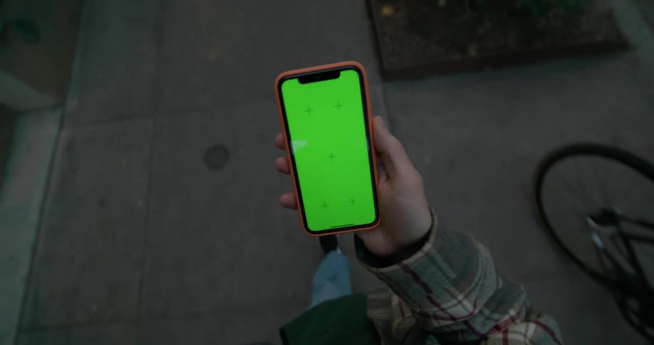 A person walks down the sidewalk using a cell phone
