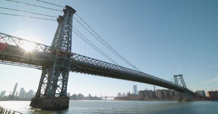 A large traffic bridge spanning a waterway in a metropolis during the day