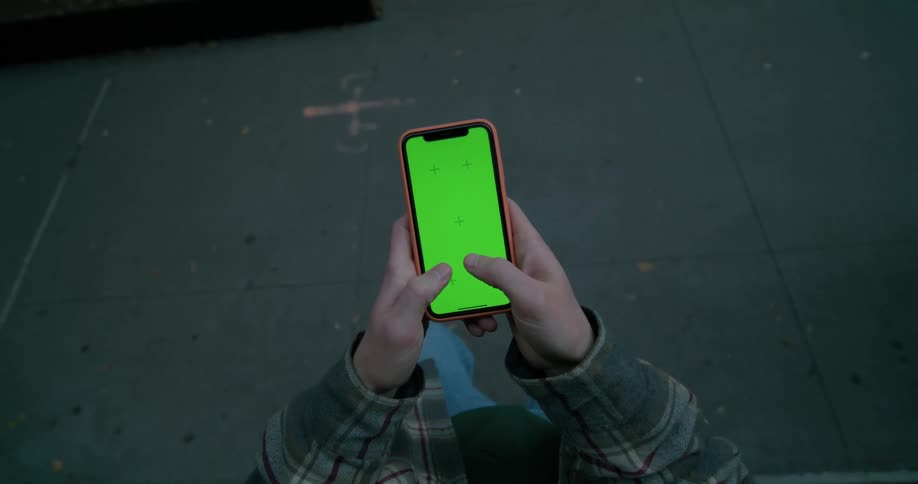 A man holding his smartphone tapping and using thumbs to text
