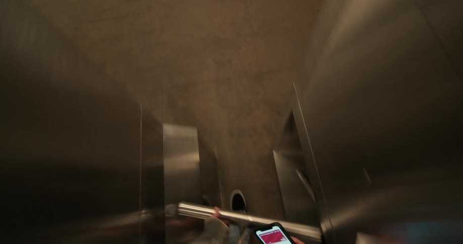 A man enters a subway station and scans his phone to gain access
