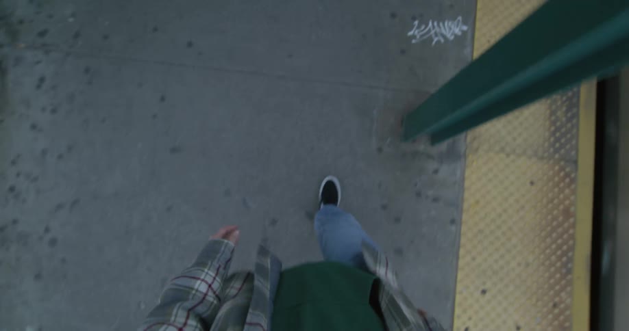 A person is walking on the train platform as the train passes