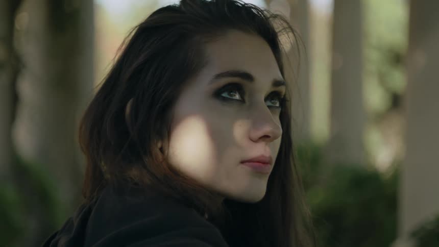 Young woman looks around sadly