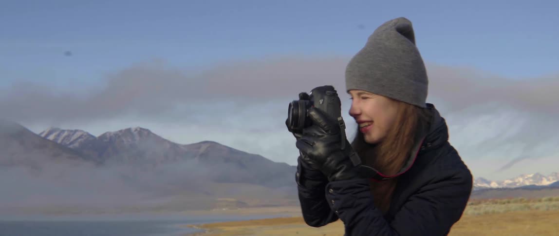 Woman Photographing the Mountain Range With Lighthearted Joy in a Peaceful Outdoor Moment.