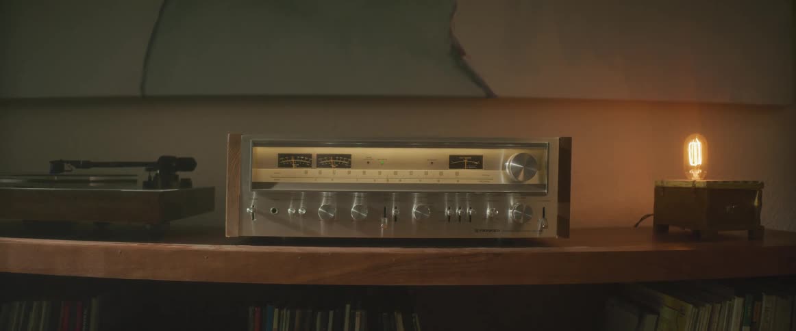Radio and record player stand sit on shelves holding records