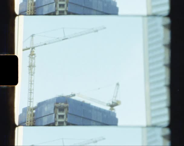 A view of a building with cranes outside it