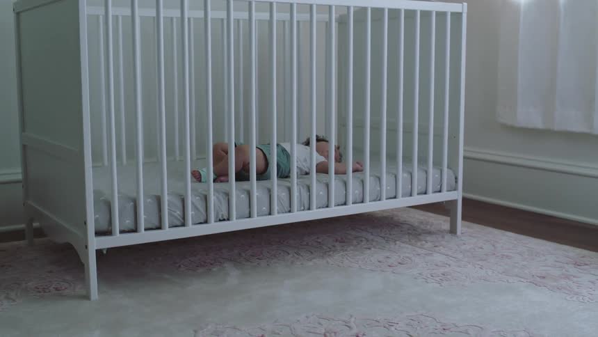 A baby sleeping in a crib during the day