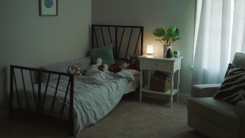 A little girl is sleeping in her bed