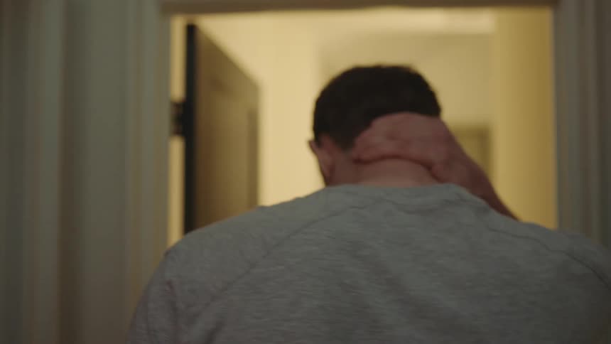 A sleepy man turns around to go back to bed