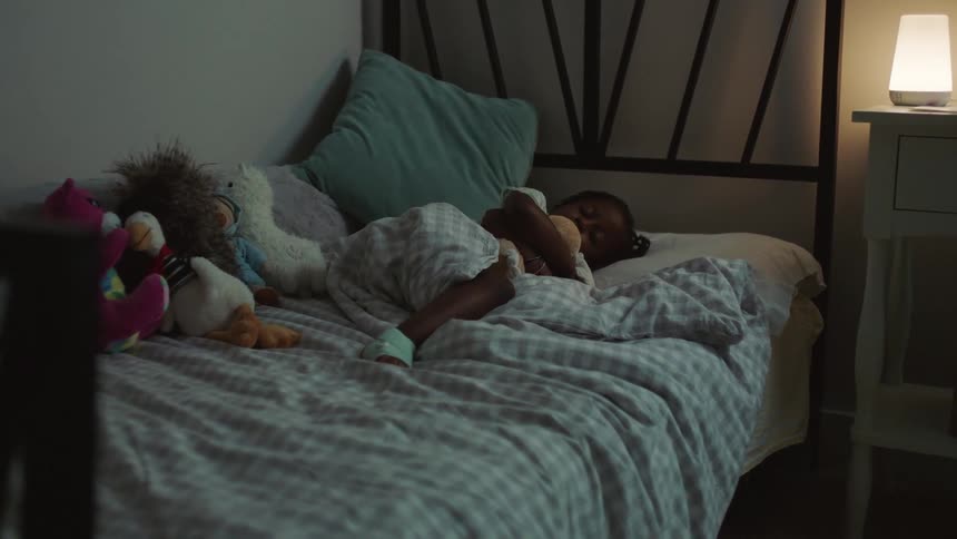 A young girl sleeps in her bed at home