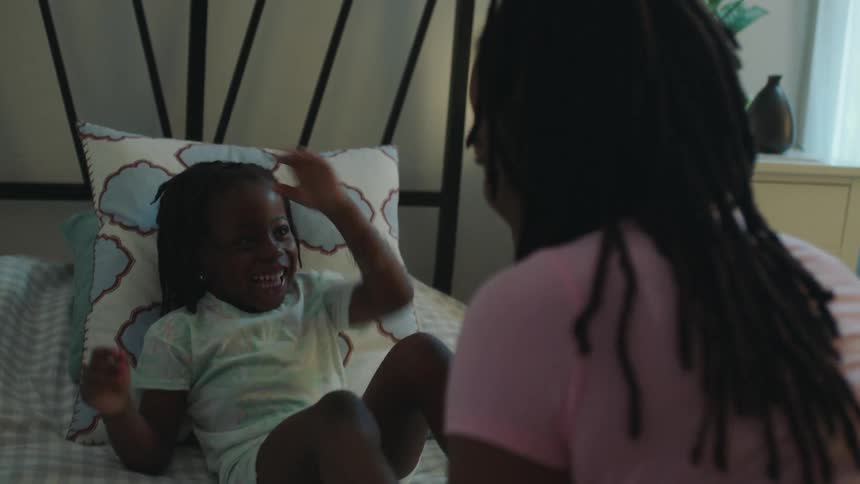 Woman plays with girl in the girls bedroom