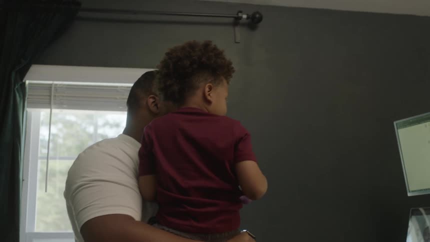 A father and son talk with people on the computer