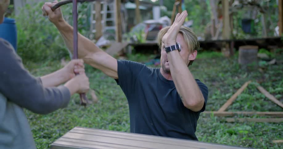 Man pretends to fight son using sticks as swords