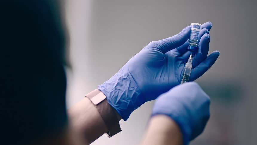 Doctor fills needle from a vial