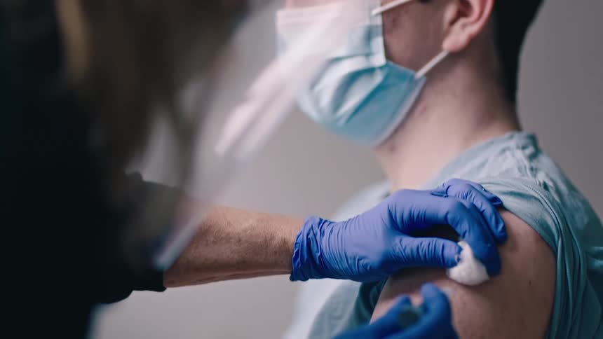 Young man gets vaccine from nurse