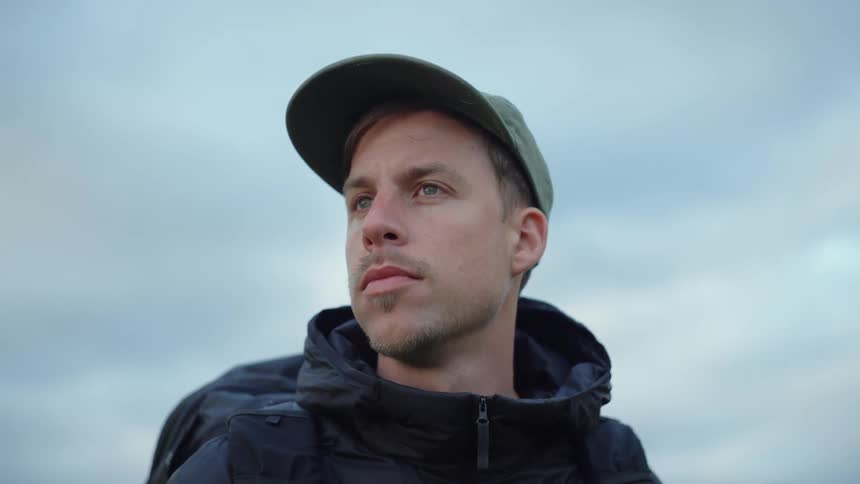 Close up of the face of a man hiking outdoors looking at the horizon on an overcast day