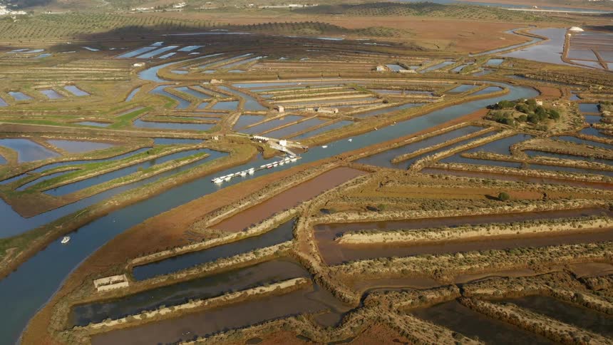 Waterway winds through crop fields and man made ponds