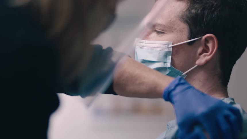 A man receives an injection in his shoulder