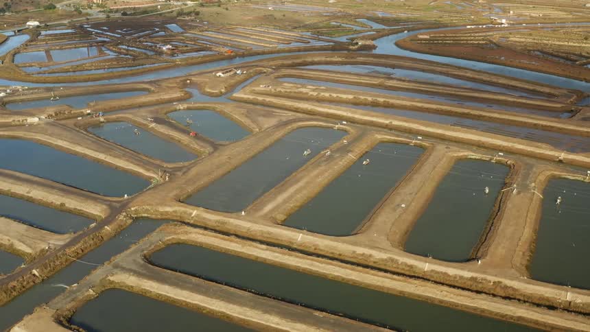Waterway passes man made ponds with concrete road access