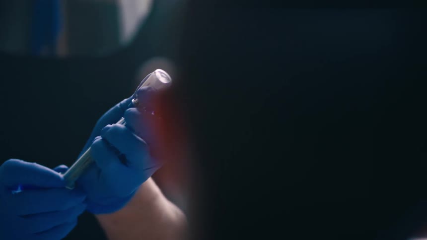 Nurse fills syringe in front of patient