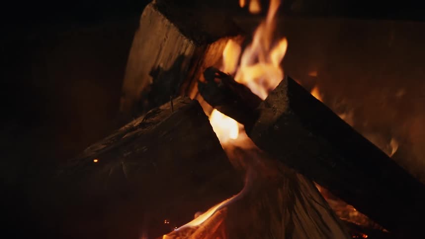 A burning smoky campfire at night