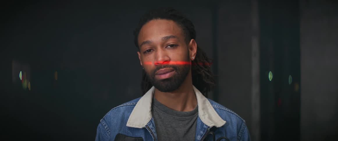 Young bearded man looking at the camera while a red laser line scans his face
