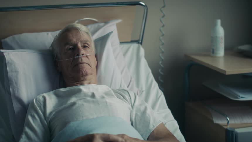 Hospital patient lies in hospital bed talking and nodding
