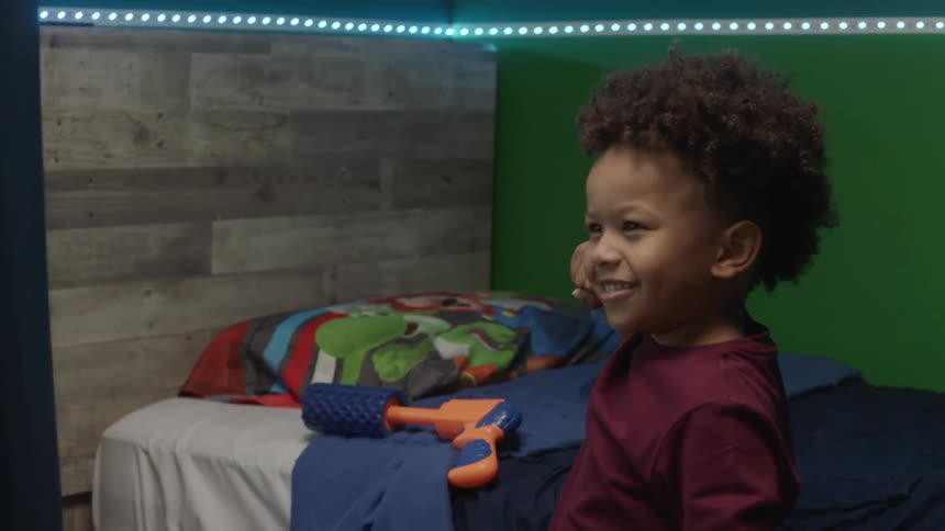 Child takes fight pose standing near bedroom