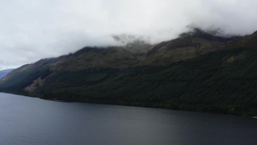 The cloud topped mountain is surrounded by water