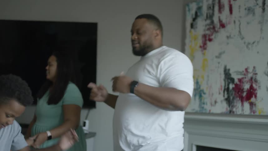 Happy family dancing together in the living room at home