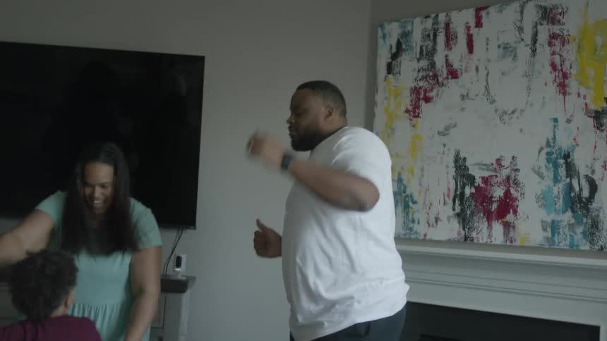 A family dancing around together in a house