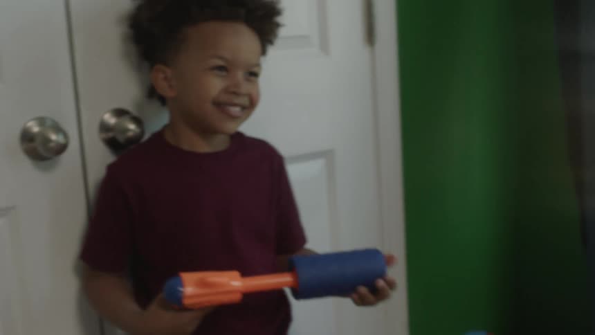 Kid and man inside the kids room playing with toy guns